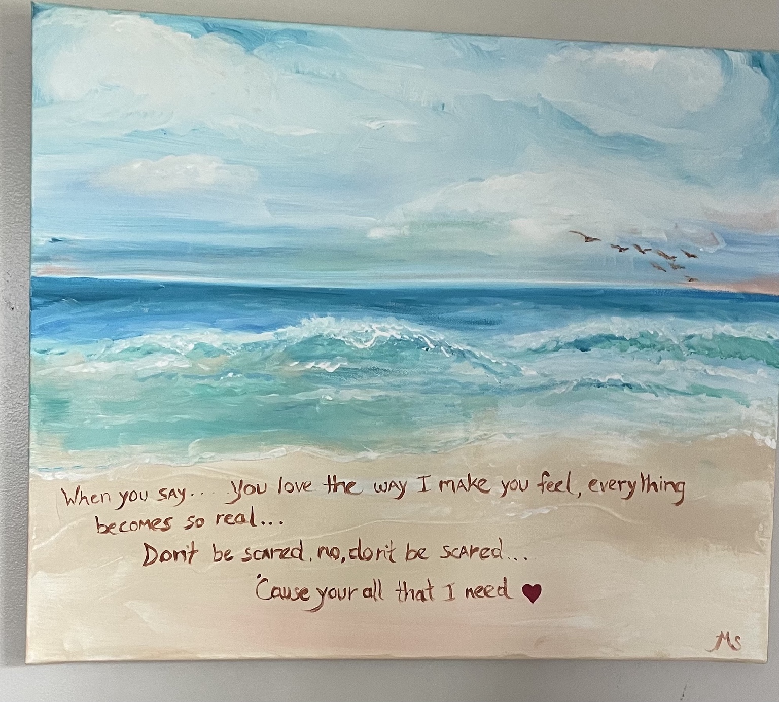 Mary's turquoise ocean painting with handwritten words in the sand