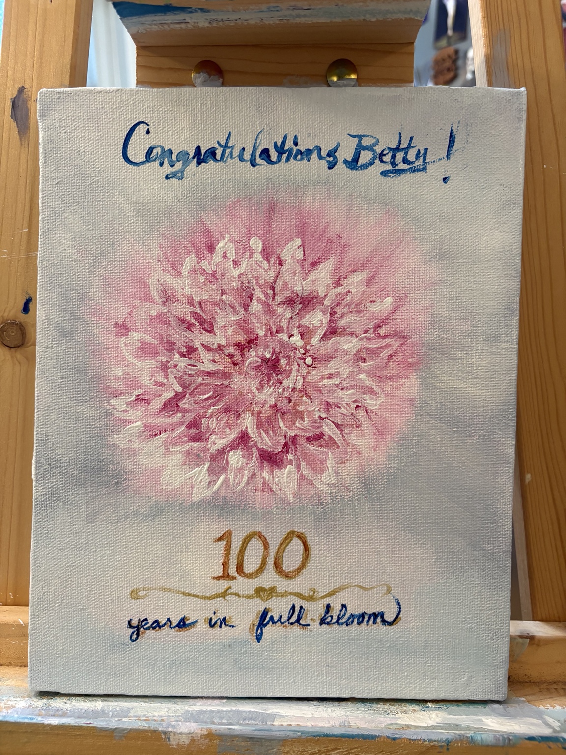 Hand-painted canvas card for Betty's 100th birthday featuring a pink flower and the words Congratulations Betty and 100 years in full bloom